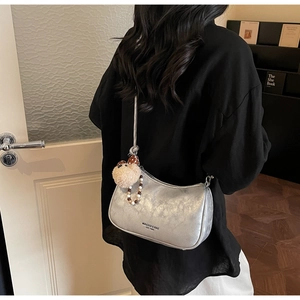 Detail of silver dumpling bag with zipper closure and bear charm accessory