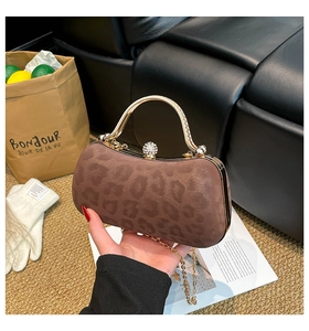 Detail of leopard print suede evening bag with gold metal handle and crystal clasp