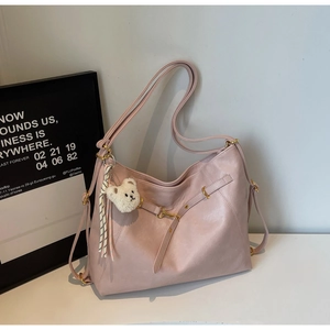 Detail of light pink Hobo shoulder bag with PU leather texture and plush bear charm