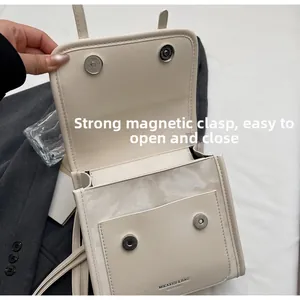 Detail of the strong magnetic closure and interior pockets of the beige satchel bag