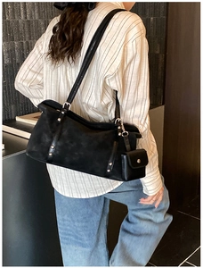 Detail of black matte leather shoulder bag with detachable mini pouch and silver hardware