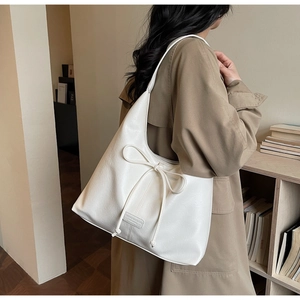 Detail of white leather shoulder bag with drawstring bow and semi-circular structure