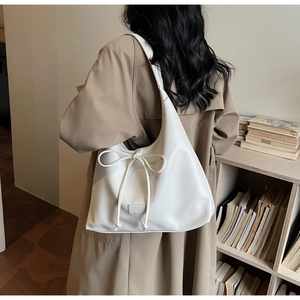 Detailed shot of white Hobo tote bag with decorative bow and large interior space