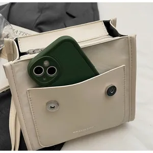 Close-up of cream square handbag showing interior capacity for a mobile phone