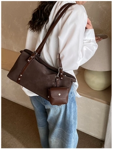 Model view of a dark brown large shoulder bag with twin straps and matching mini pouch
