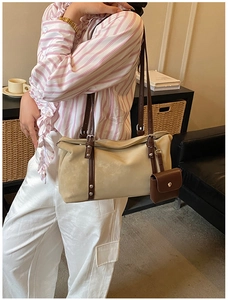 Close-up of beige suede shoulder bag with brown straps and detachable mini pouch