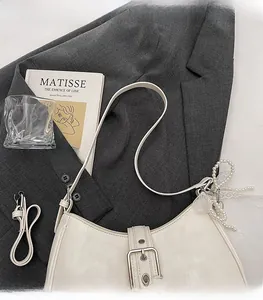 Vue détaillée du sac beige en similicuir avec nœud en dentelle et perle décorative