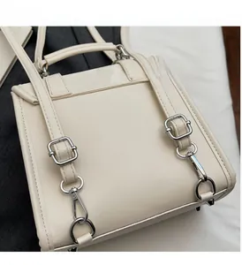 Detailed macro of premium silver-tone metal hardware and glossy off-white leather tote bag