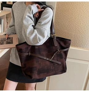 Macro detail of vintage tote bag showing textured canvas and brown leather strap buckle