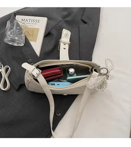 Vue intérieure d'un sac à bandoulière blanc montrant sa grande capacité et sa poche