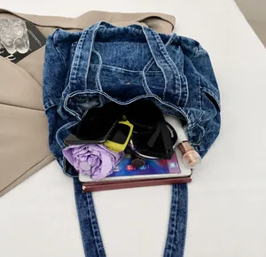 Vista detallada de la capacidad interna del bolso tote denim con accesorios