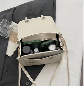 Interior view showing the large capacity and storage compartments of the cream white crossbody bag