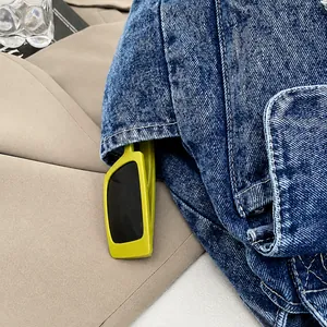 Detalle de un bolso de hombro en denim azul con bolsillo lateral y gafas de sol modernas