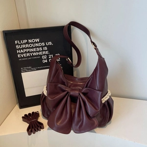 Vintage burgundy shoulder bag with large bow, lace trim, and adjustable strap