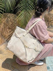 Large cream tote bag with adjustable straps shown in an outdoor lifestyle setting