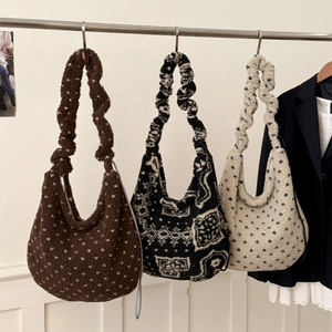 Dettaglio di tre borse hobo in peluche con tracolla a pieghe in varie fantasie moda