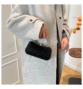 Détail du sac à main léopard noir avec poignée ronde dorée et fermoir en strass