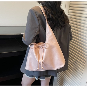 Detailed view of pink bow-knot large capacity tote bag worn with a grey blazer