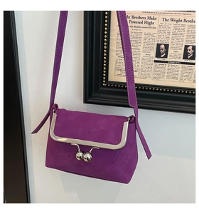 Detail of purple faux suede mini bag with silver kiss-lock clasp and metal frame