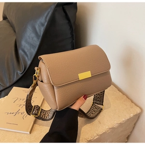Détail du sac bandoulière kaki en cuir avec fermoir doré et large bandoulière tissée