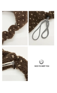 Dettaglio borsa in pile marrone a pois con cuciture ondulate, coulisse e cerniera argento