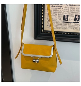 Detail of bright yellow lychee pattern leather bag with vintage metal bead clasp