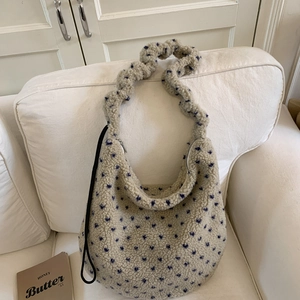 Dettaglio borsa tote beige in pile con stelle blu e tracolla arricciata