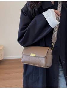 Sac bandoulière en cuir marron avec une large sangle aux motifs ethniques variés