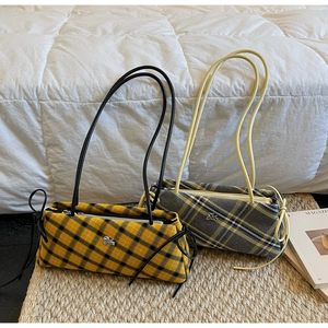 Close-up of large plaid shoulder bags with tweed texture and silver metal logos