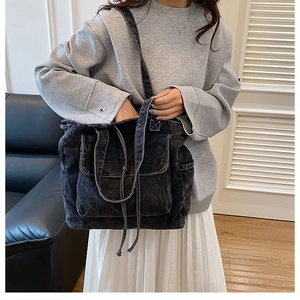 Modelo con bolso tote de mezclilla gris oscuro con bolsillo frontal y cordones