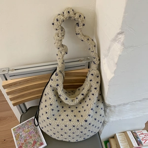 Dettaglio della borsa hobo in peluche crema con motivo a piccoli fiori blu