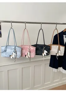 Quatre sacs cabas à carreaux colorés avec pendentifs cheval suspendus à une barre