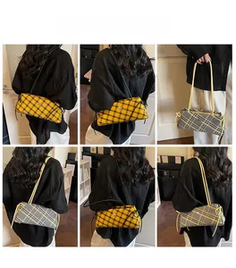 Detail showing two plaid hobo bags in yellow and grey patterns with leather shoulder straps