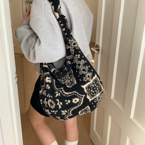 Dettaglio della borsa hobo in pile a motivo paisley bianco e nero e forma morbida