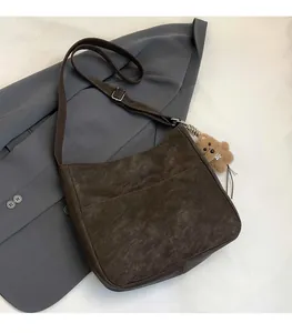 Sac hobo marron foncé avec texture mate et accessoire de pendentif ours mignon