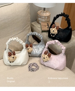 Detail of ruched hobo bags in four colors featuring teddy bear charms and chain straps