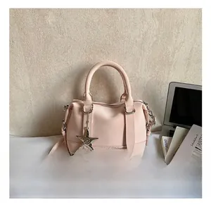 Detail of pink pillow handbag with silver star charm and adjustable shoulder strap