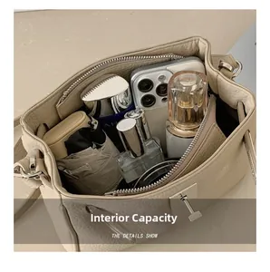 Vista superior del bolso de cuero beige que muestra gran capacidad interna con objetos