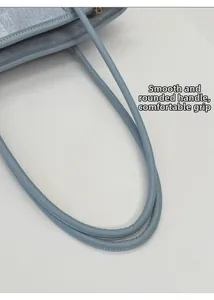 Détail du sac en cuir bleu clair avec poignée arrondie et prise en main confortable
