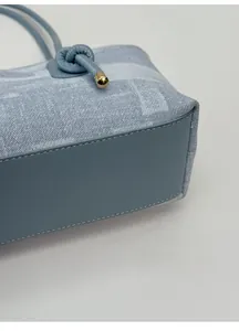 Gros plan d'un sac cabas en jean bleu clair avec fond en cuir épais pour le support
