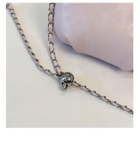 Detail of light pink lychee leather handbag with adjustable silver ball chain strap