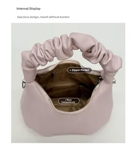 Detail showing the inner main compartment and metal zipper pocket of pink ruched bag