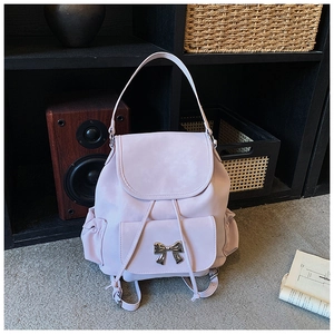 Detail view of a lavender backpack with silver bow buckle on minimalist background