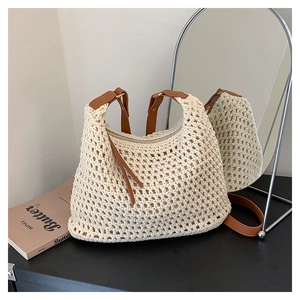 Dettaglio della borsa tote intrecciata crema con tracolla in pelle marrone e frange