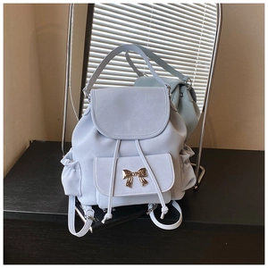 Close-up of a light blue casual backpack featuring a silver metal bow buckle detail
