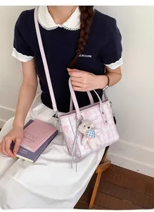 Détail du sac seau à carreaux roses avec imprimé ours cartoon et breloque en peluche