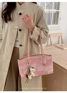 Détail du sac cabas rose texturé avec motifs color-block et un pendentif cheval en cuir