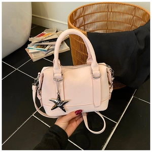 Detail of light pink Boston handbag with silver starfish charm and dual handles