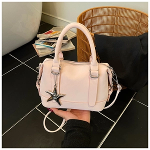 Detail of light pink leather Boston bag with silver star charm and detachable strap