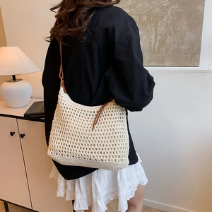 Dettaglio borsa tote in crochet beige con trama a rete e tracolla in pelle marrone